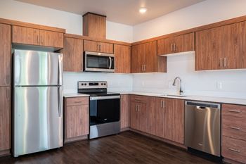 a kitchen with wooden cabinets and stainless steel appliances
